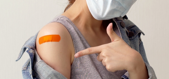 - A-Woman-Showing-bandage-on-her-arm-where-she-received-Flu-Jab