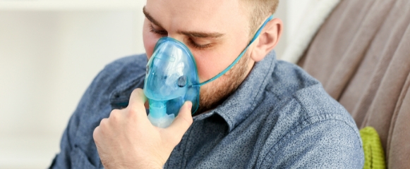 man with oxygen mask looking sad after diagnosed with pneumonia