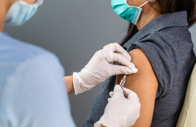 Doctor giving vaccine to a woman pilgrim going on hajj